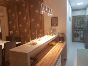 a kitchen with a long counter with a stove at Apartamento Homeland 305 in Gramado