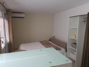 Habitación pequeña con cama y armario en Chambre-Studio Mare Bianca, en Saint-Florent
