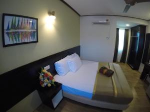 una camera d'albergo con un letto fiorito di Anjung Villa a Pantai Cenang