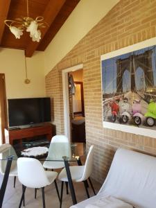 een woonkamer met een tafel en stoelen en een televisie bij Agriturismo La Stradaccia in Ginestreto