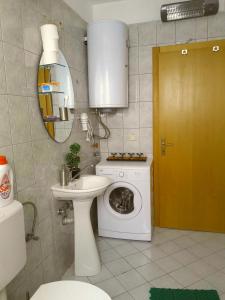 La salle de bains est pourvue d'un lave-linge et d'un lavabo. dans l'établissement Tiffany Apartment, à Ohrid