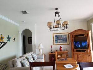 a living room with a couch and a chandelier at My Florida Lake House in Homestead