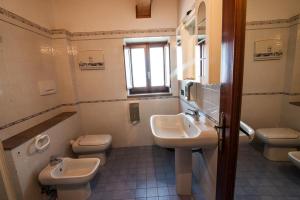 a bathroom with two sinks and two toilets and a window at Lo Sparviero in Gerace