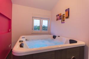 ein Badezimmer mit einer großen Badewanne mit blauem Wasser in der Unterkunft Apartments Villa Pupa in Trogir