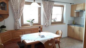 eine Küche mit einem Tisch und 2 Fenstern in der Unterkunft Apartment Marlene in Alpbach