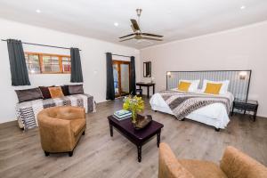 uma sala de estar com uma cama e um sofá em Le Petit Chateau Guest House em Durbanville