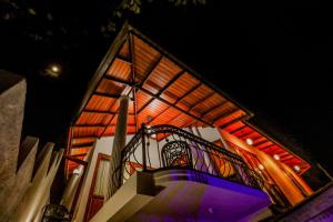 a building with a staircase and a balcony with lights at Travellers Home in Kandy