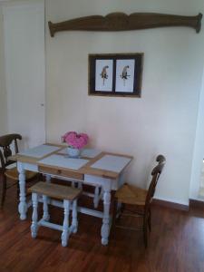 a table with two chairs and a table with flowers on it at L'AURE BLEUE in Bayeux