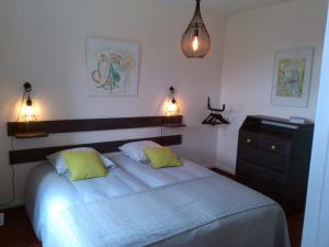a bedroom with a bed and a dresser and lights at L'AURE BLEUE in Bayeux