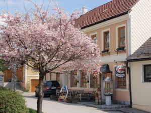 a flowering tree in front of a building at Gasthof zur Kirche in Kottes