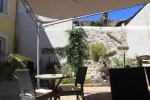 an outdoor patio with a table and chairs at Le Logis GOUT in Carcassonne