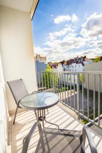 een tafel en stoel op een balkon met uitzicht bij Apartament Victoria in Sopot