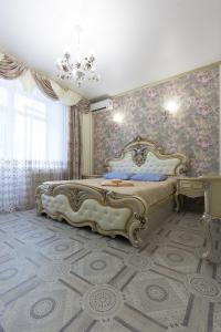 - une chambre avec un grand lit et un mur orné de fleurs dans l'établissement Apartments Lux pl.Lenina 10/3, à Astrakhan