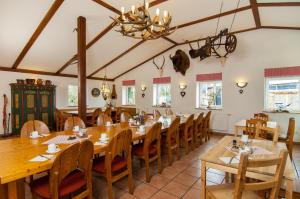 comedor grande con mesas y sillas de madera en Hotel garni Godenhof, en Wanderup