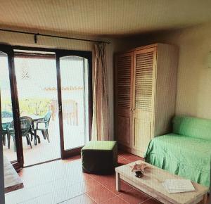 アッビアドリにあるSardegna Resortのベッド1台、バルコニー(テーブル付)が備わる客室です。