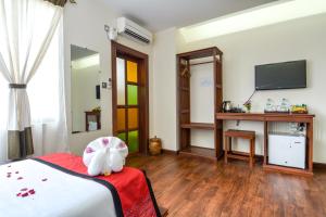 a bedroom with a bed with a stuffed animal on it at Hotel Queen Jamadevi in Mawlamyine