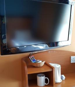 a flat screen tv on top of a wooden table at Chatsworth Hotel in Hastings