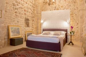 コンヴェルサーノにあるDei Balzi Dimore di Charmeのレンガの壁に大きなベッドが備わるベッドルーム1室が備わります。