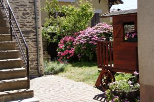 a garden with pink flowers and a wooden cart at La chambre du harpiste in Saint-Mars-la-Jaille +3 photos