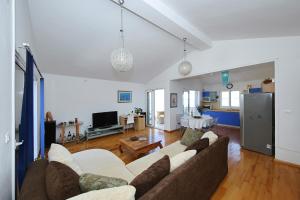 a living room with a couch and a tv at Punta Preko Apartments in Preko