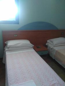 a bedroom with two beds and a table with a window at Regina di cuori in LʼAquila