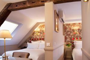 1 dormitorio con 2 camas en un ático en Hôtel des Comédies en París