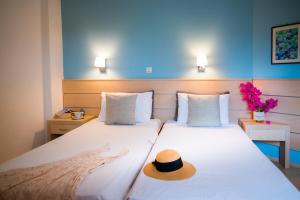 a hotel room with two beds with a hat on them at Melissa Apartments, Studios & Suites in Malia