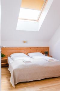Schlafzimmer mit einem großen Bett und einem Dachfenster in der Unterkunft Stranachwirt Apartments in Sankt Michael im Lungau