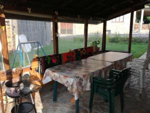 a table and chairs on a screened in porch at Къща за гости Шотарови in Dospat