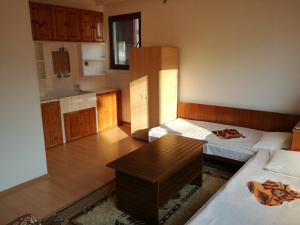 a room with two beds and a table in it at Къща за гости Шотарови in Dospat