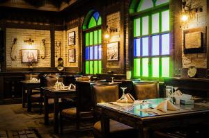 a restaurant with tables and chairs and stained glass windows at Karan Sharq for Hotel Apartments Company in Al Jubail