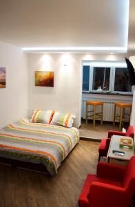 um quarto com uma cama e uma cadeira vermelha em Nikola's Apartment em Belgrado