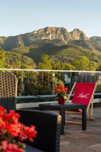 ザコパネにあるHotel Logosの山々を背景にテーブルと椅子が備わるパティオ