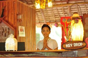 une femme debout derrière un comptoir dans un restaurant dans l'établissement Mek Kiri Riverkwai Resort SHA, à Thong Pha Phum