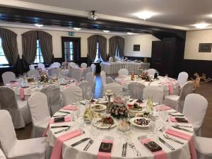 a banquet hall with white tables and white chairs at Hotel - Bar Grafaite in Šiauliai +88 photos