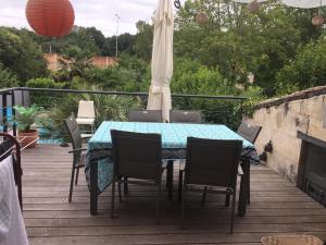 une table et des chaises assises sur une terrasse avec une table dans l'établissement Maison (villa) de charme avec piscine, à Carbon-Blanc