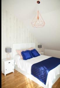 - une chambre avec un lit doté d'oreillers bleus dans l'établissement Atico Jaca Oroel, à Jaca