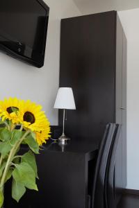 a vase with a sunflower on a desk with a lamp at Hotel Ambassadeur in Ostend