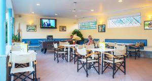 two people sitting at tables in a restaurant at Melissa Apartments, Studios & Suites in Malia