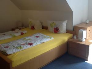 1 Schlafzimmer mit 2 Betten mit gelber Bettwäsche und Kissen in der Unterkunft Landgasthof Gruss in Brilon