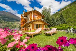 a log cabin in the mountains with flowers at Hotel Le Bouquet - Adults Only in Cogne