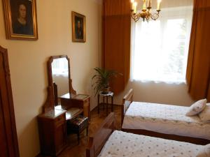 a bedroom with two beds and a mirror and a window at Apartament Krakowski Styl in Krakow