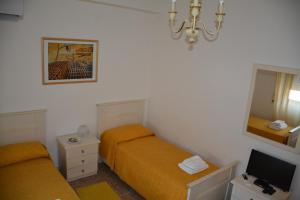 罗马Andreina a San Pietro Apartment的一间卧室设有两张床、镜子和电视