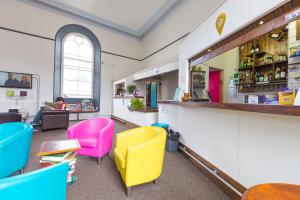 a restaurant with colorful chairs and a counter at Cohort Hostel in St Ives