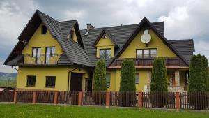 a yellow and black house with a black roof at Agroturystyka Jędruś - Nocując u nas otrzymasz 20 procent zniżki na termy Gorący Potok i Szaflary in Szaflary