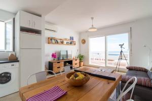 リンコン・デ・ラ・ビクトリアにあるApartamento Sietecolores Sea Viewのキッチン、リビングルーム(フルーツの盛り合わせ付きのテーブル付)