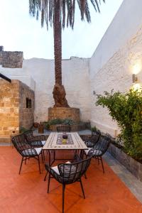 a patio with tables and chairs and a palm tree at Belvedere Medieval Villa in Rhodes Town