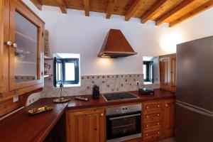 a kitchen with wooden cabinets and a stainless steel refrigerator at Belvedere Medieval Villa in Rhodes Town
