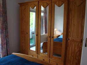 un armadio in legno con specchio in una camera da letto di Apartment Angelique a Bad Harzburg