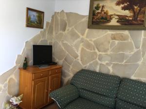 sala de estar con sofá y pared de roca en Casa Rural Anzo, en Gáldar